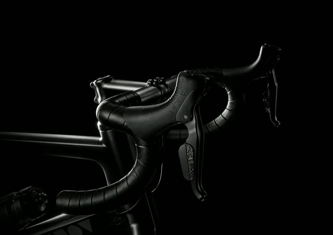 Close detail of a MUOV cockpit — stem, handlebar and brake lever in low light
