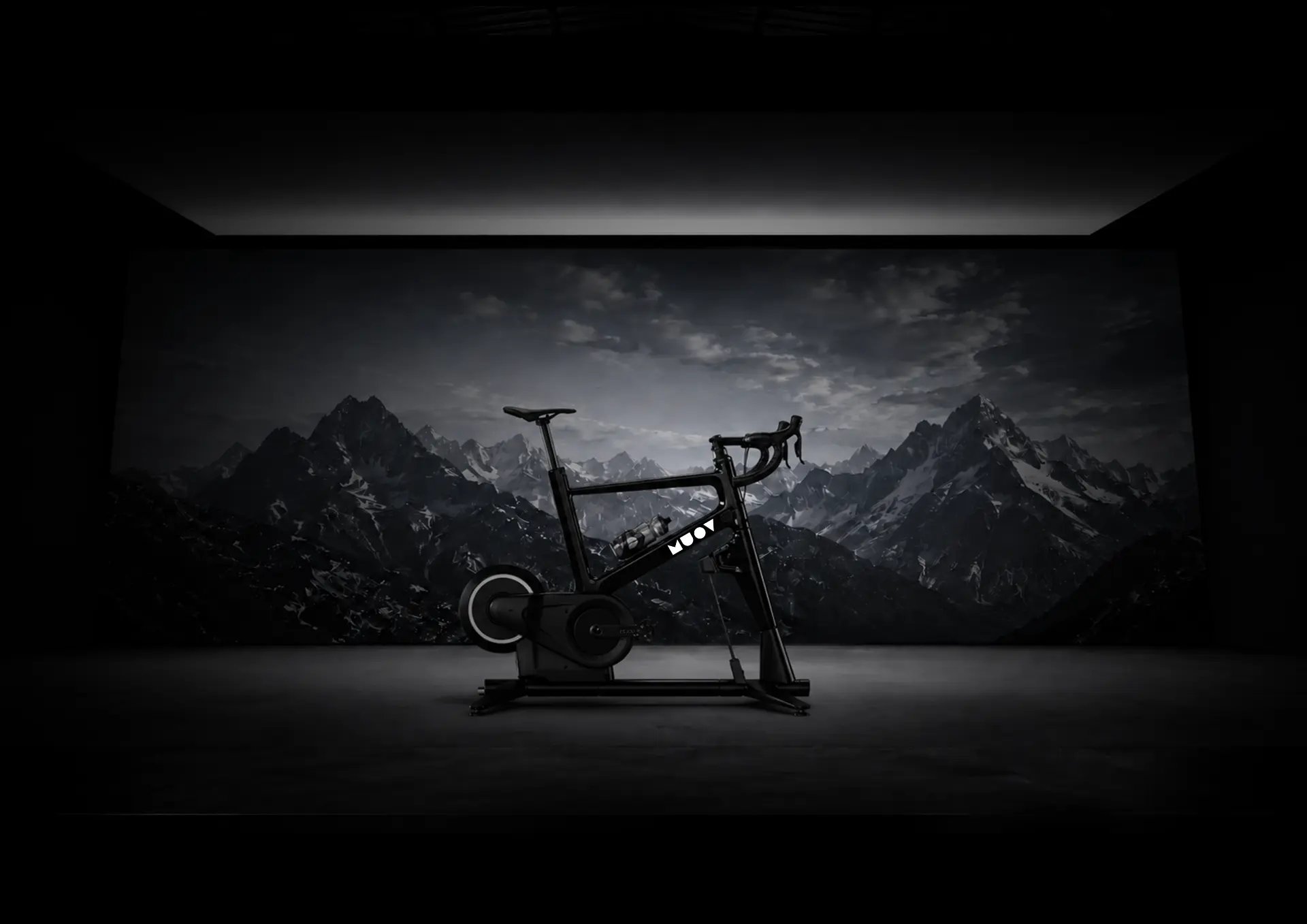MUOV bike in a dark studio in front of a mountain landscape